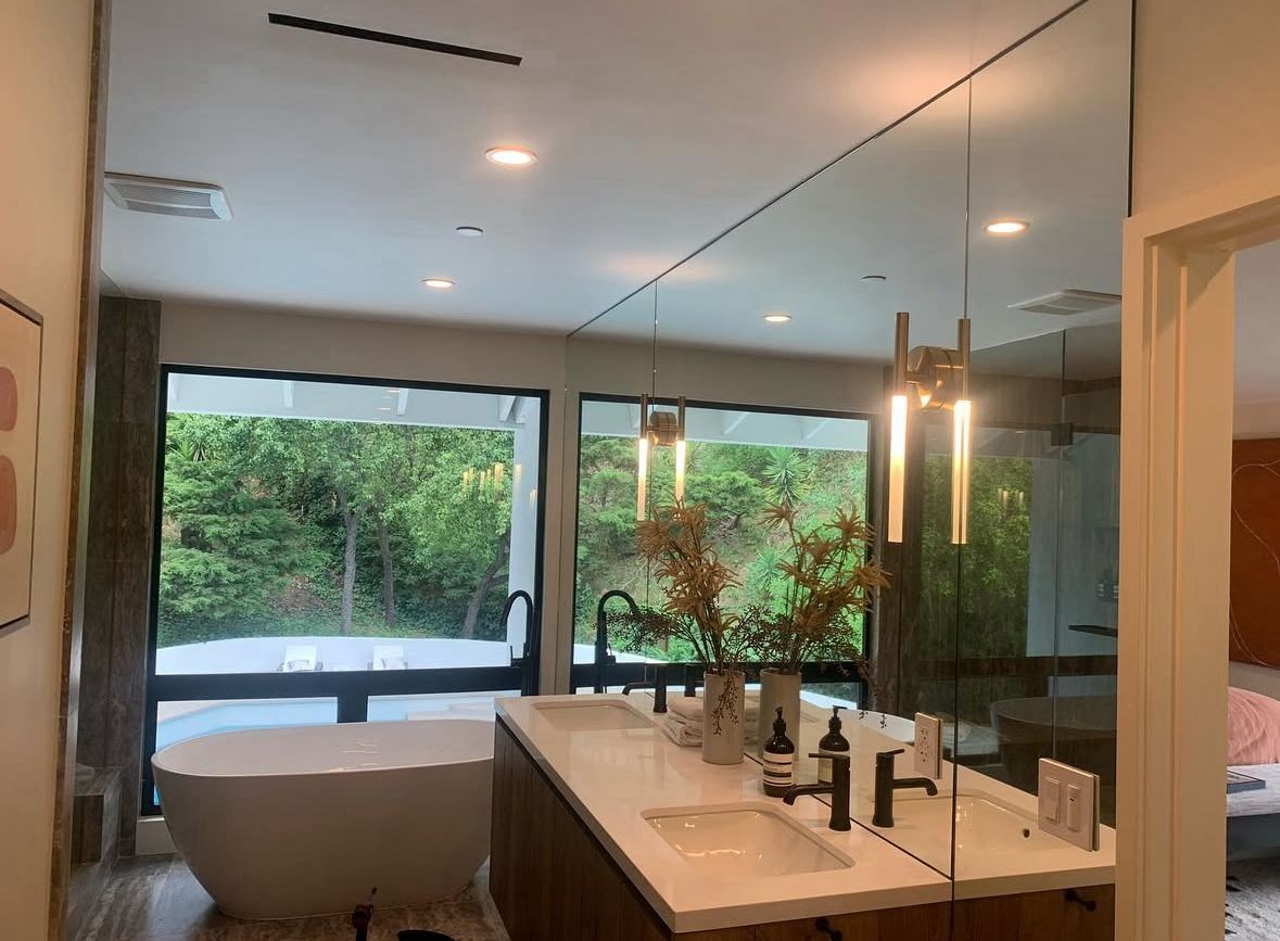 Luxury bathroom with custom glass shower enclosure and mirror wall