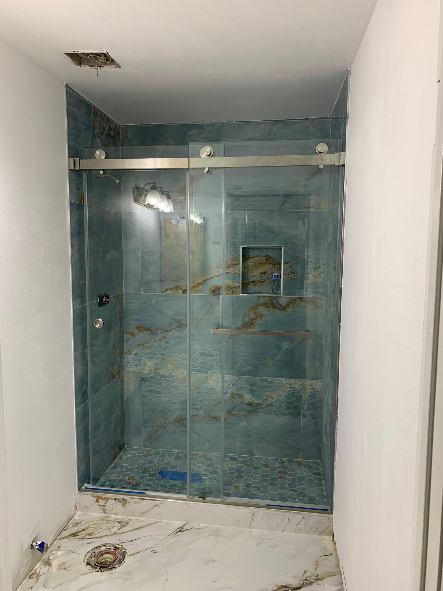 Blue marble shower with custom glass enclosure