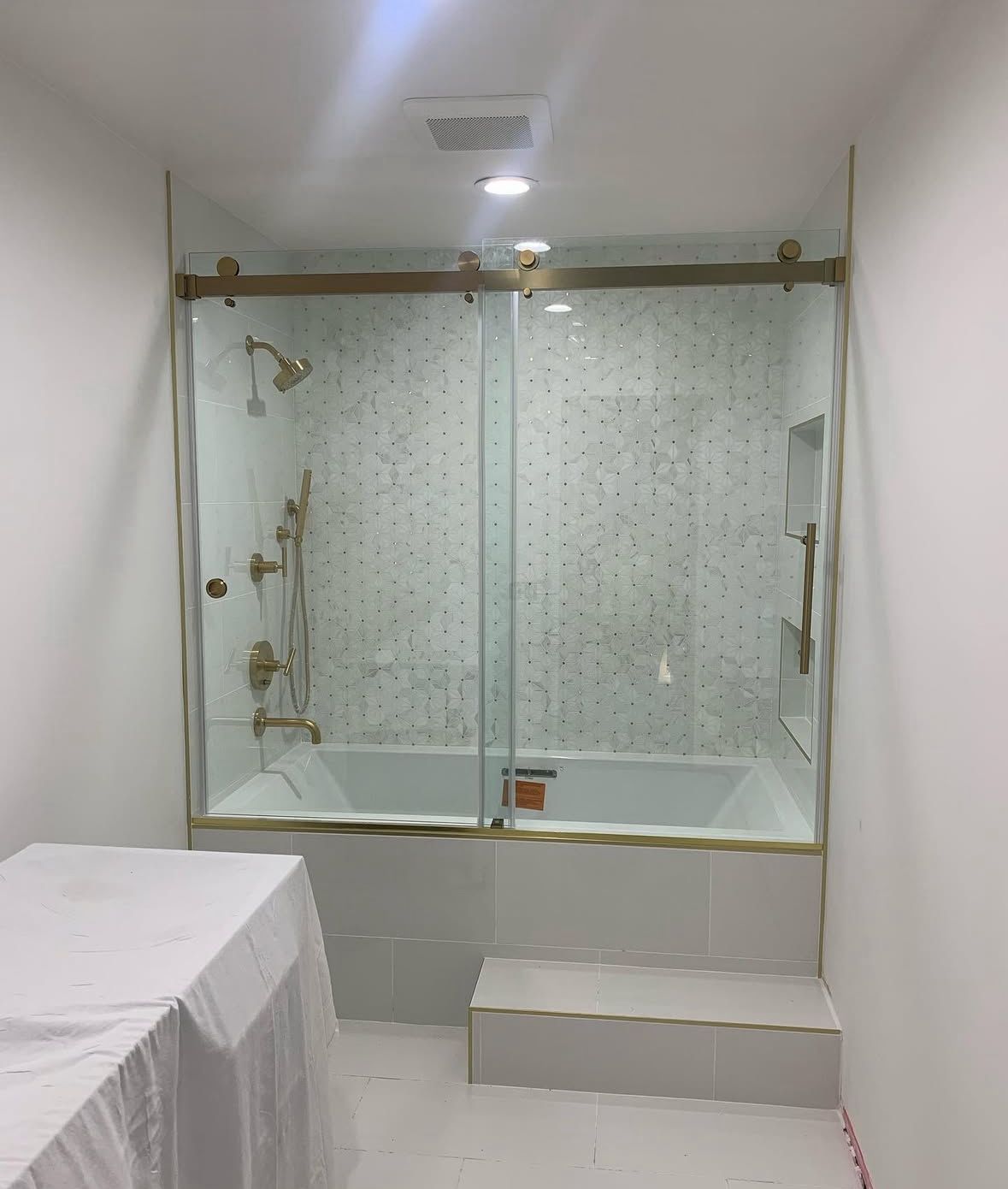 Sliding glass shower door with gold fixtures